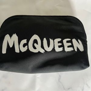 Brand new McQueen Toiletry Pouch. Black with white writing. Orange interior.